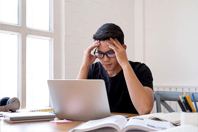 Stressed Student Studying Hard for Exam in the Classroom